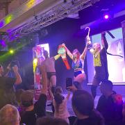 Villainous group The Monarchy made up of Wrestling Society UK owner and wrestler Nadia Sapphire (middle) Rishi Ghosh (right) and RJ Singh (left) celebrating a dastardly title win to the dismay of the Swindon crowd