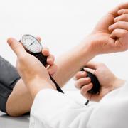 Doctor measuring blood pressure - studio shot on white background.