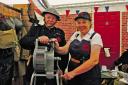 Tommy and Vera, dressed as wartime Auxiliary Fire Service personnel,operate a siren