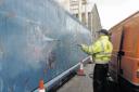 A council worker clears graffiti