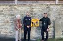 Chair of the Parish Chris Watts, Chris Smith, the Christ Church Community Centre Manager, and Margaret Williams, a local resident, standing with the new defibrillator